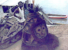 [Pius loading a large dance tumbuan onto our double canoe at Mindimbit Village, Sepik River: 19k]